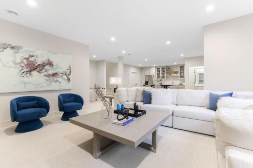 The lower level spacious family room is perfect for gatherings and seamlessly provides a luxurious living area.