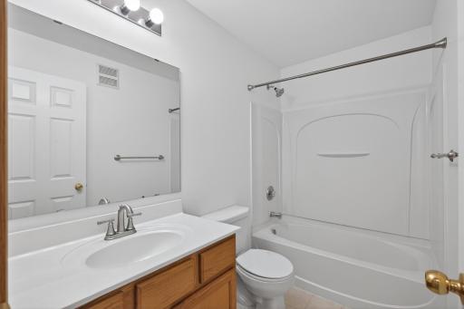 Fresh and functional bathroom with updated fixtures and full tub/shower surround.