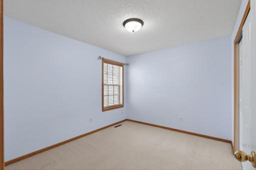 Comfortable secondary bedroom with soft natural light and neutral finishes ready for any style or setup.