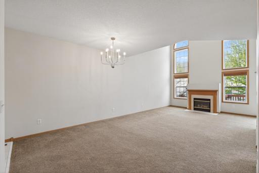 Step inside to soaring ceilings, oversized windows, and a dramatic two-story living room filled with natural light and anchored by a cozy gas fireplace.