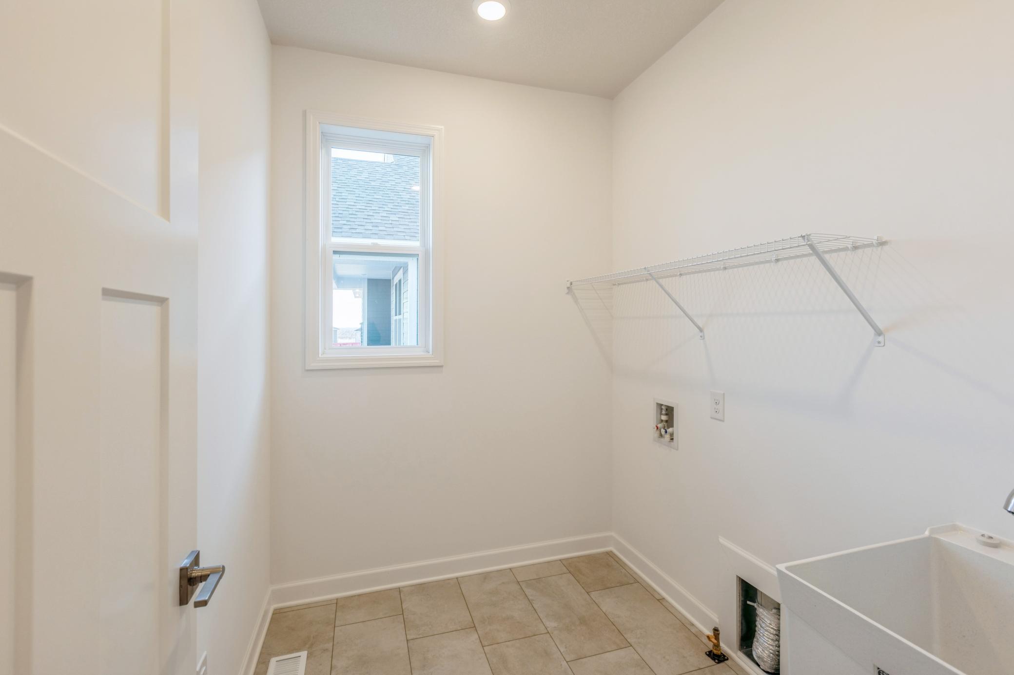 (Photo of a similar home, actual finishes may vary) The spacious laundry room features plenty of space for a new washer and dryer.