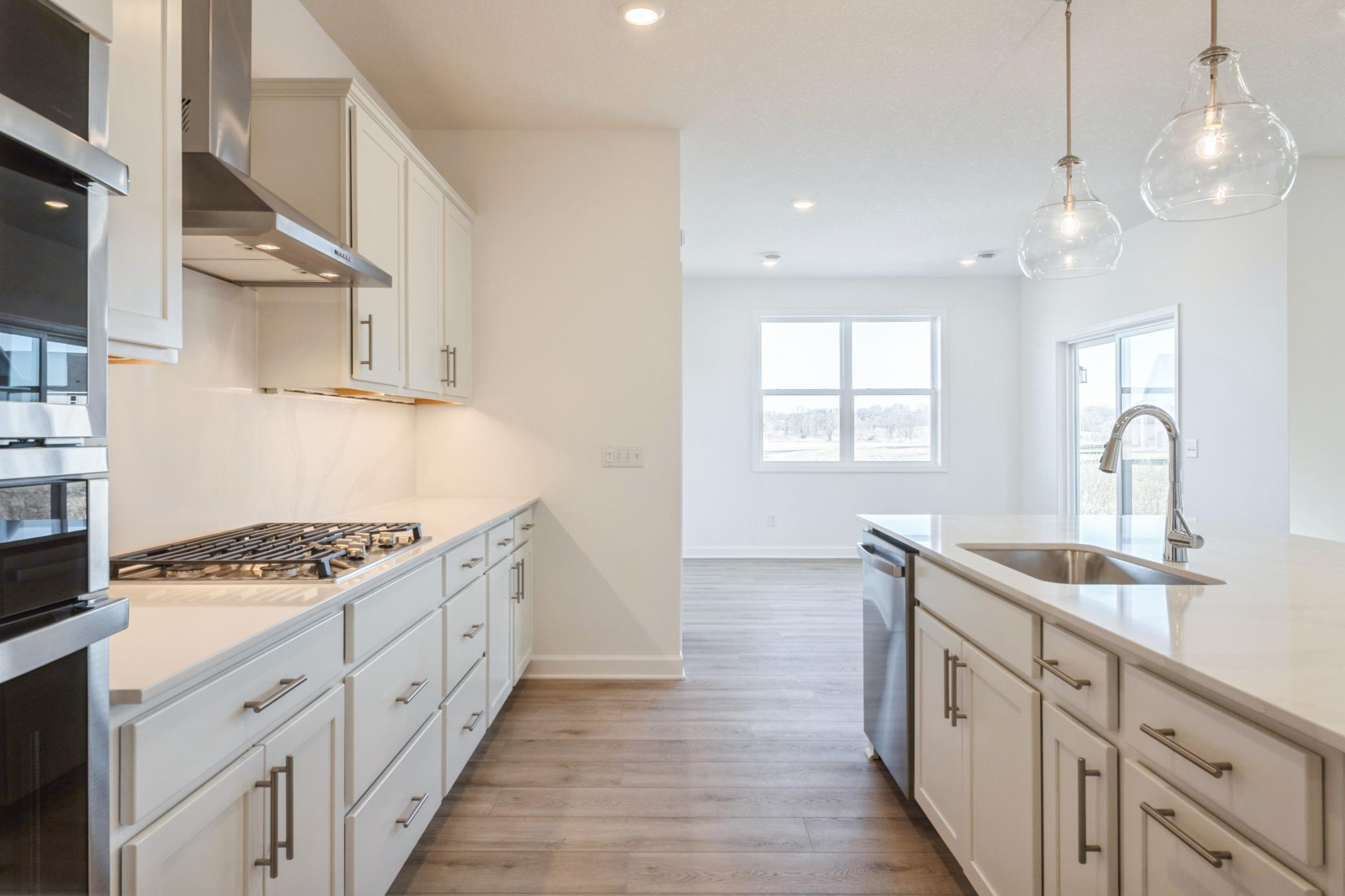 (Photo of a similar home, actual finishes may vary) An open-design kitchen flows seamlessly into the dining room, simplifying mealtimes