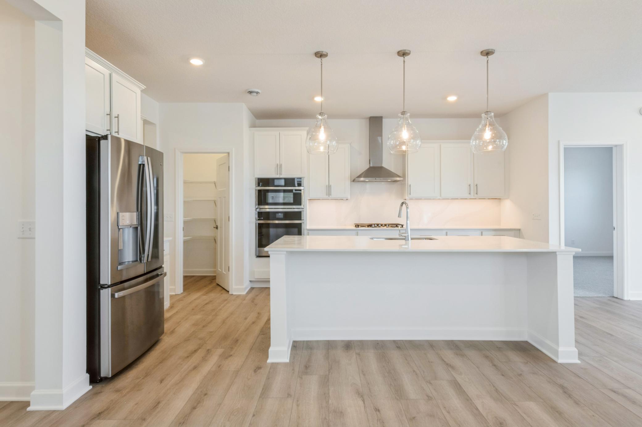 (Photo of a similar home, actual finishes may vary) Featuring a brand-new stainless steel appliance package, a large rectangular center island and a pantry, the stylish kitchen is well equipped for cooks of all skill levels.