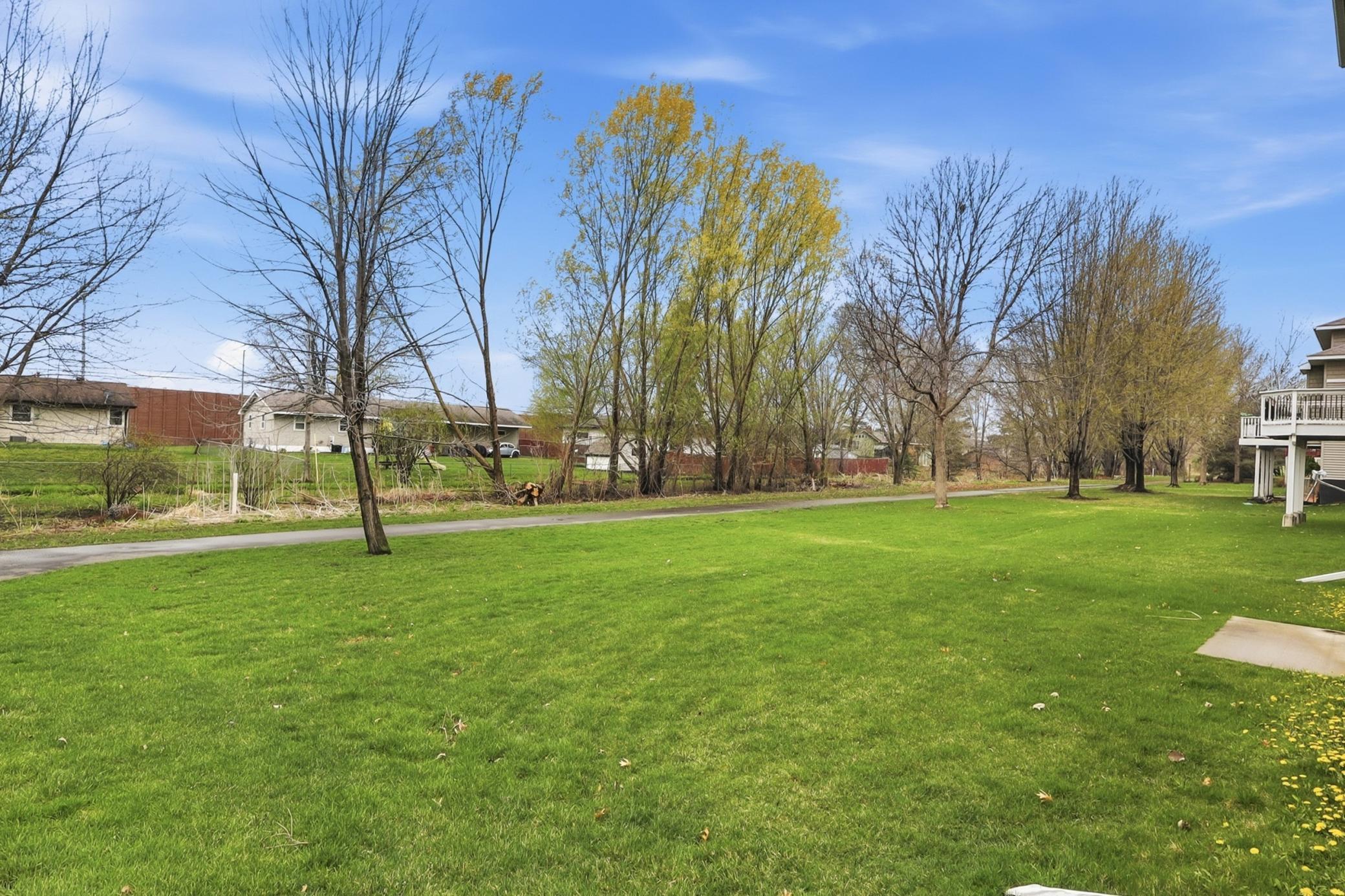 Flat backyard that backs to a mature tree line and walking path