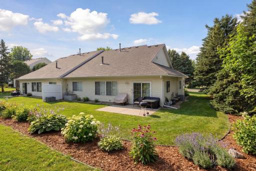 Private backyard with patio, privacy fence, and colorful perennials