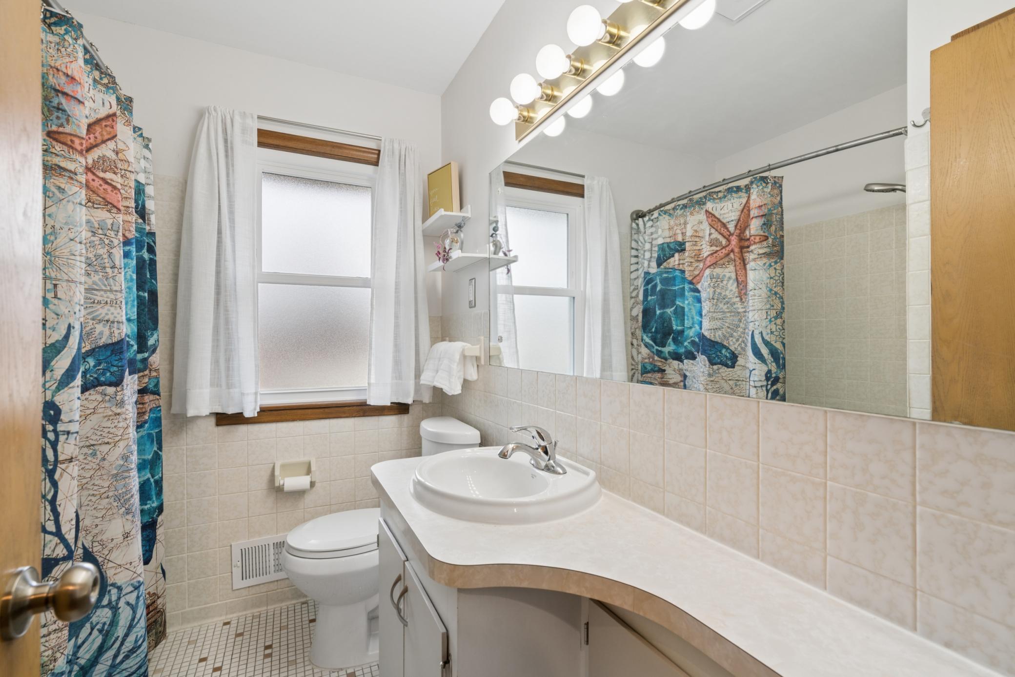 Full bathroom on the main level with plenty of counter space and large beautiful mirror