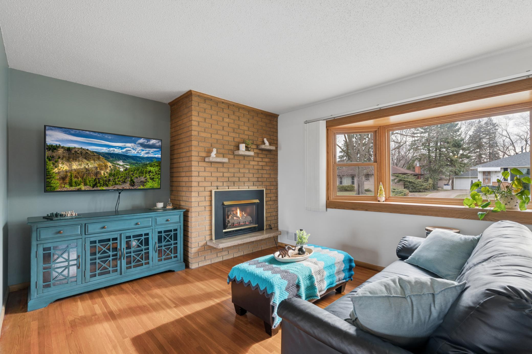 Sun-filled living room highlighted by a beautiful bay window and a cozy gas fireplace