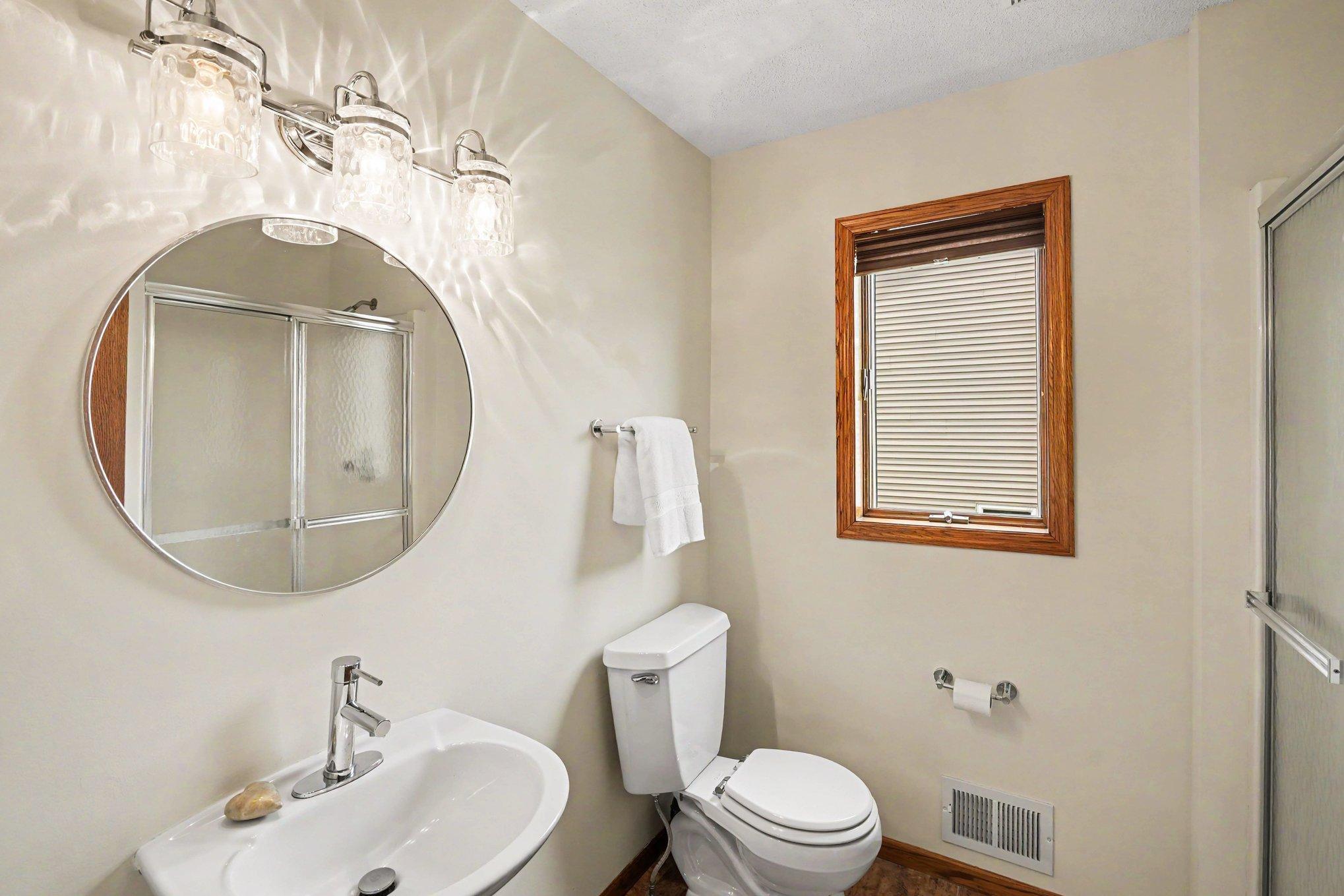 The main level features a 3/4 bathroom with a lovely pedestal sink & ceramic tile floors.
