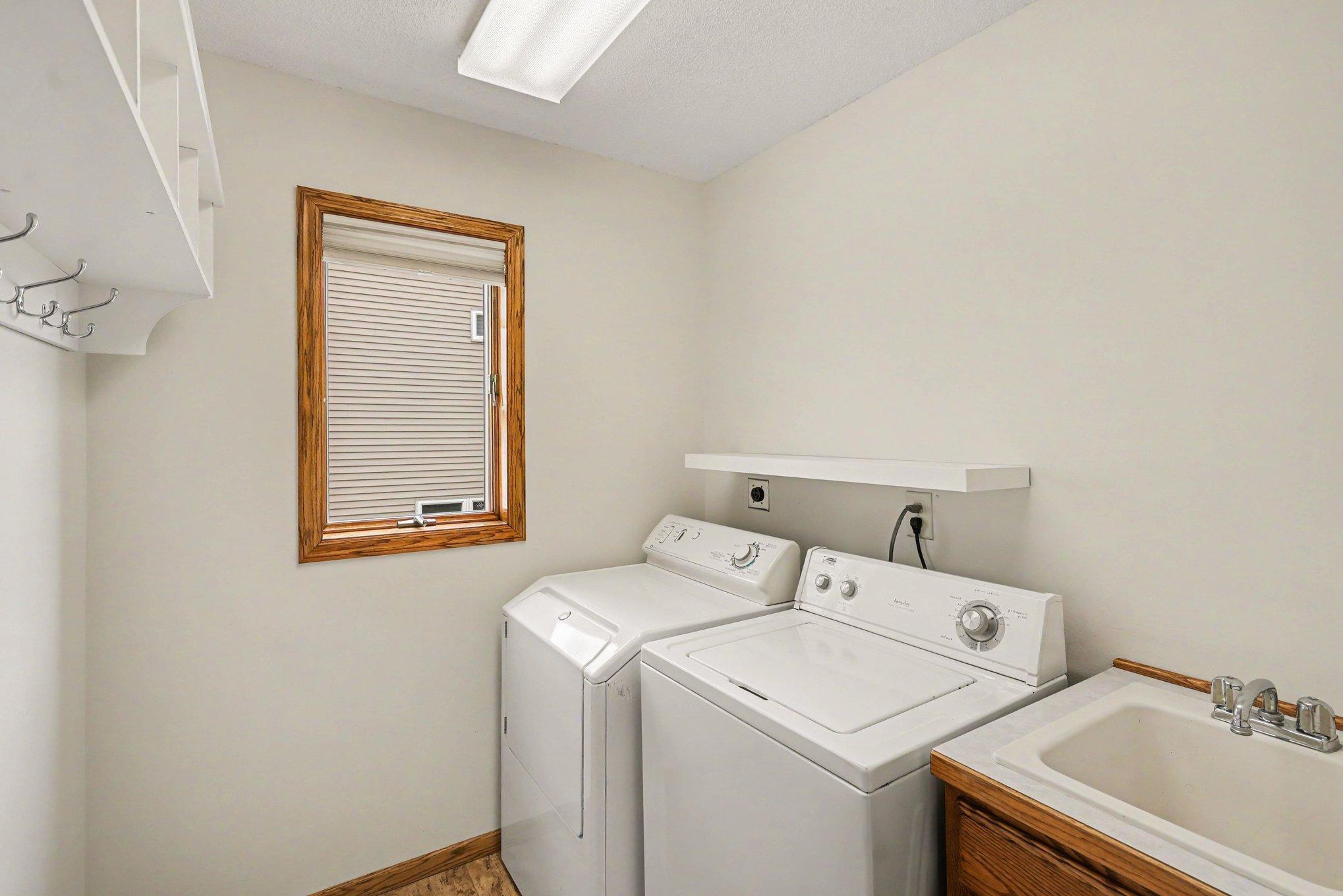 Conveniently located by the garage entry, the laundry room features ceramic tile, a utility sink, and a bright window. Complete with a washer and gas dryer & a hallway coat closet, it’s a functional mudroom and laundry space in one!