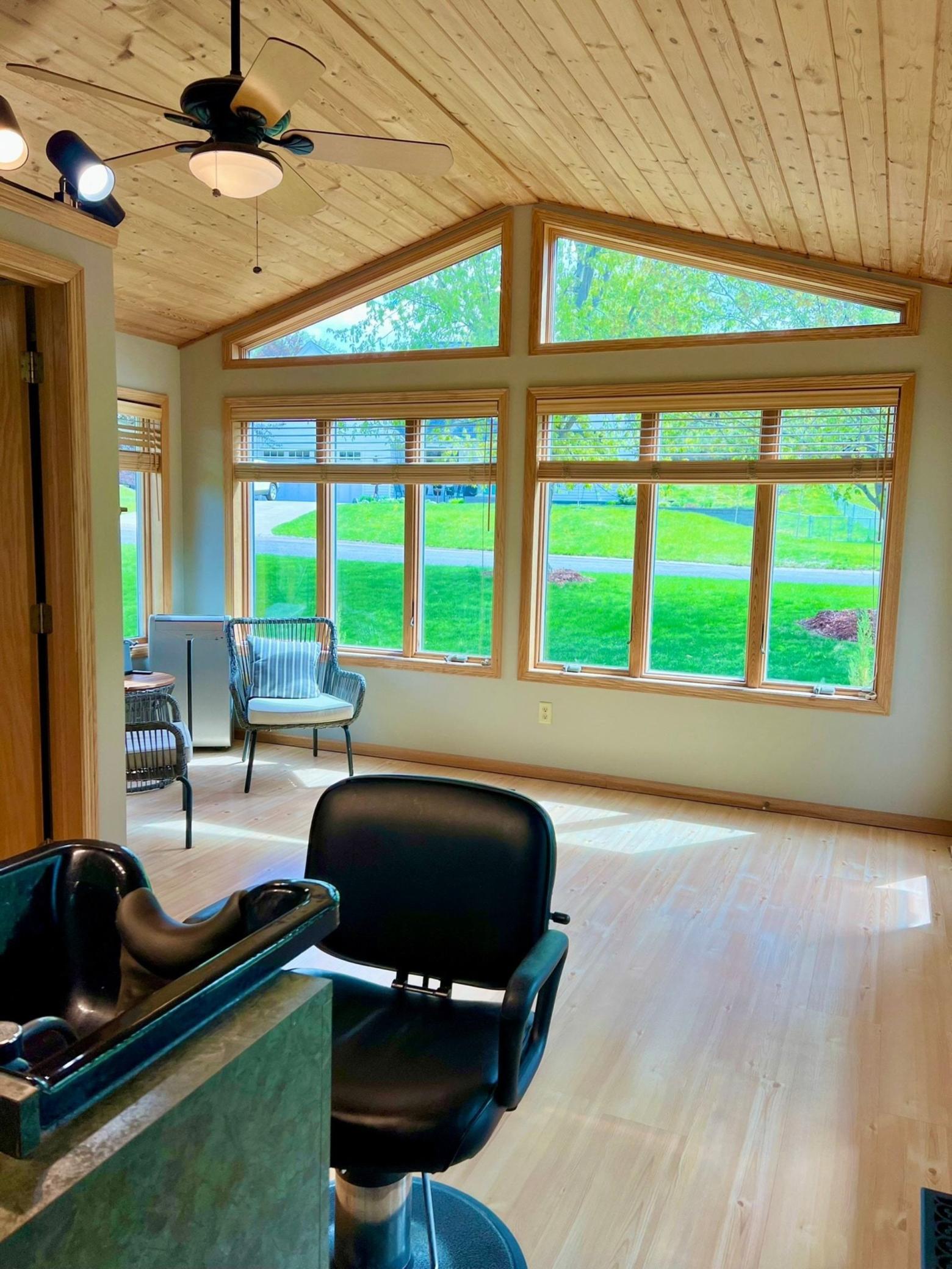 This view showcases the sunroom's expansive wall of windows, which floods the space with natural light. The result is a bright, warm, and cozy atmosphere that’s perfect for clients or personal relaxation.