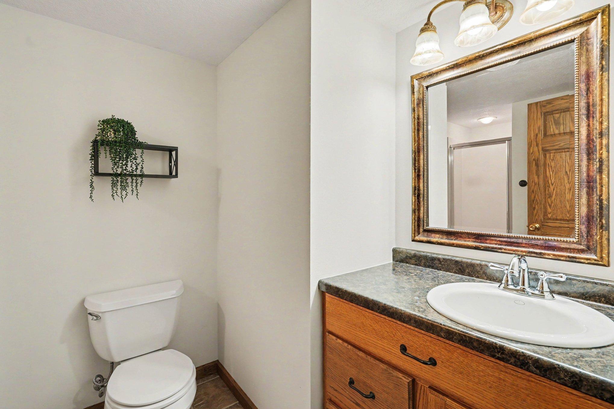 The lower level features a 3/4 bathroom with ceramic tile floors & a vanity with storage.