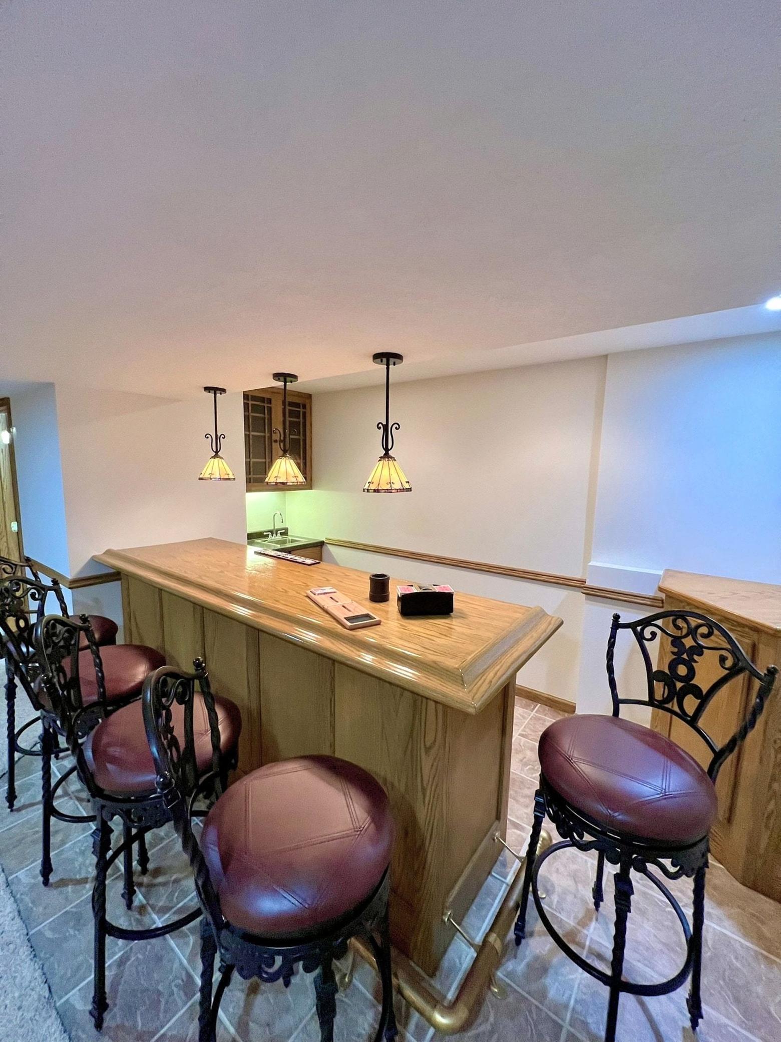Invite friends to belly up to your personal bar! This party-ready setup features a tiled floor, a sink, and plenty of storage for your favorite spirits and glassware. The perfect hub for hosting and unforgettable gatherings!