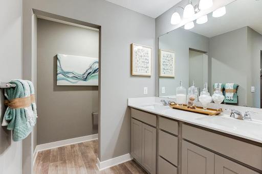 The primary en suite includes a double-vanity, walk-in shower and serves as the passage way to the bedrooms second oversized walk-in closet!! Picture of previously built model home, finishes, selections, and colors will vary.