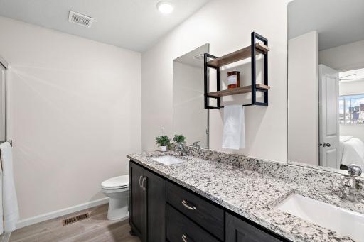 The primary bathroom has double sinks, a shower, and plenty of storage.