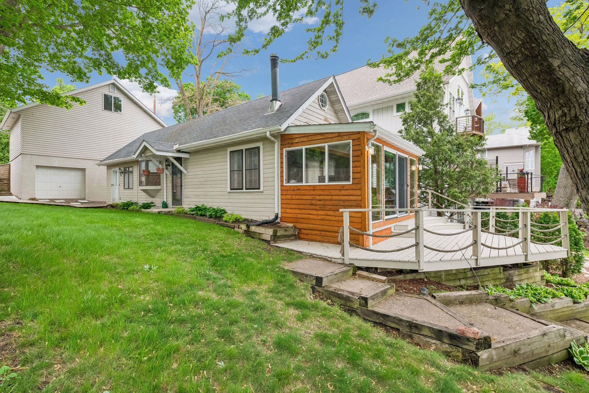 Side view of home showing lower level garage entrance and pathway to home plus deck that overlooks Harrison Bay.