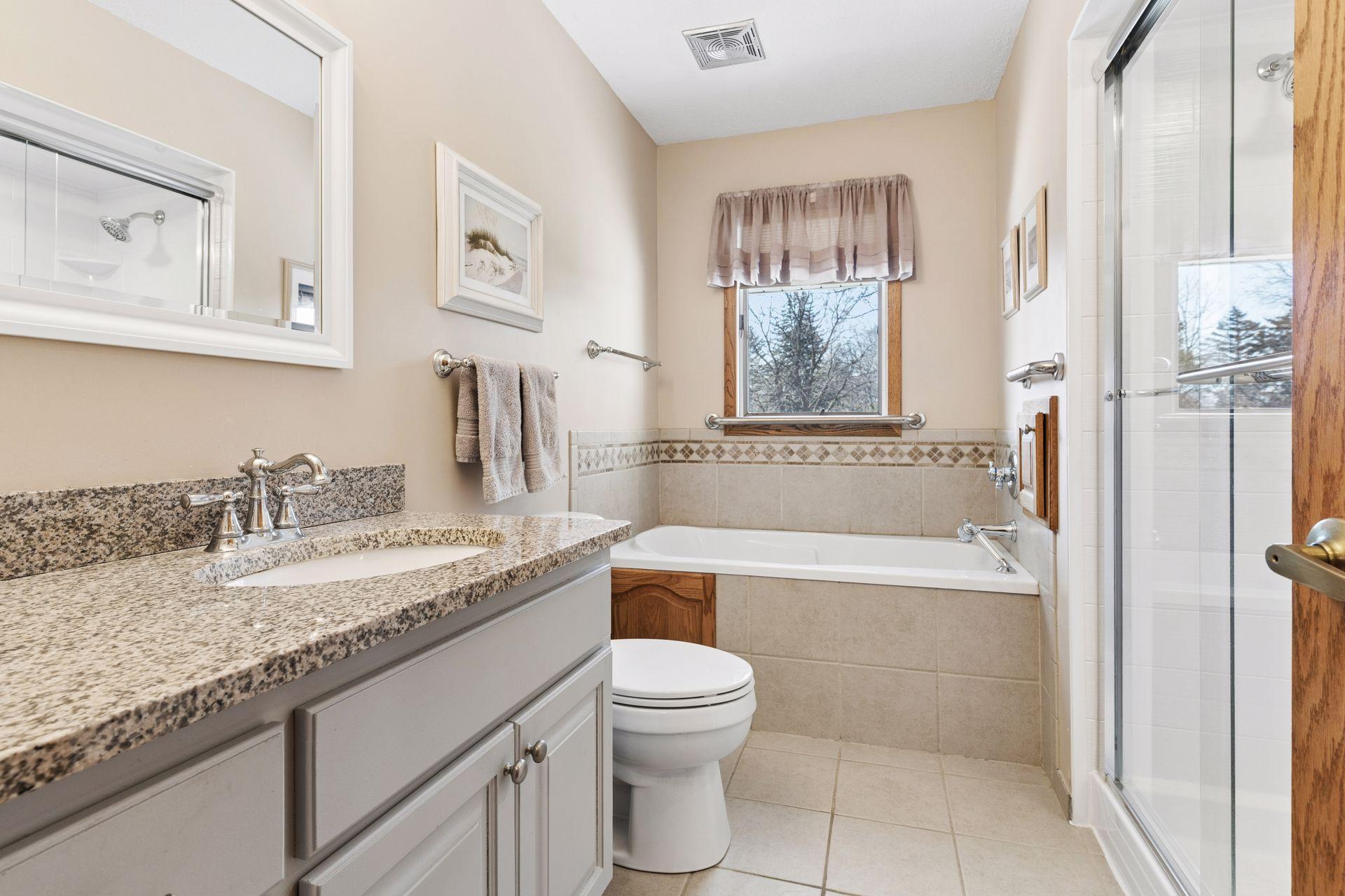 Upper level full bath with granite counters, heated floors, jetted tub and new Bath Fitter walk-in shower.