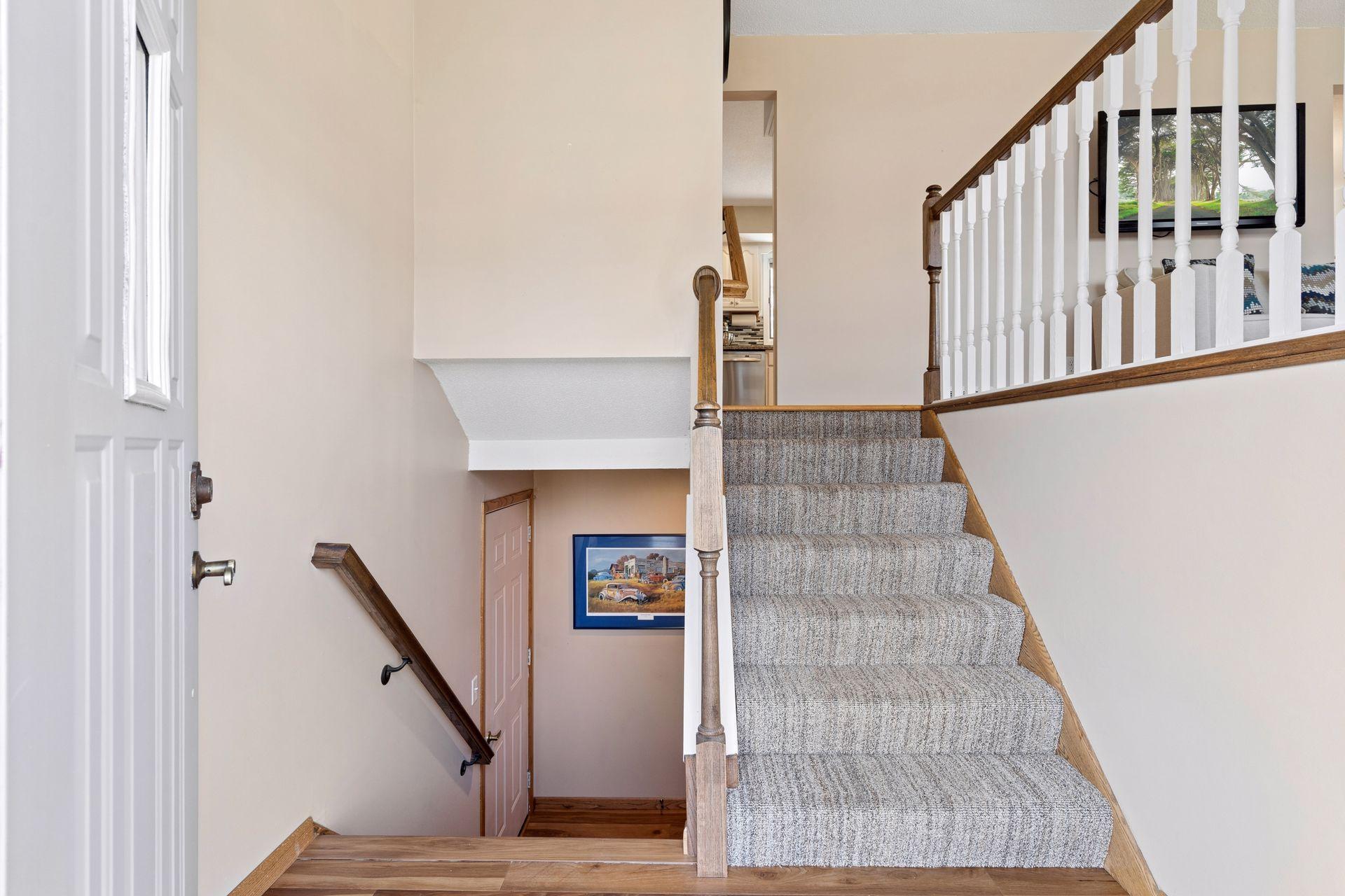 Front entry. View to upper floor and lower stairs to garage.