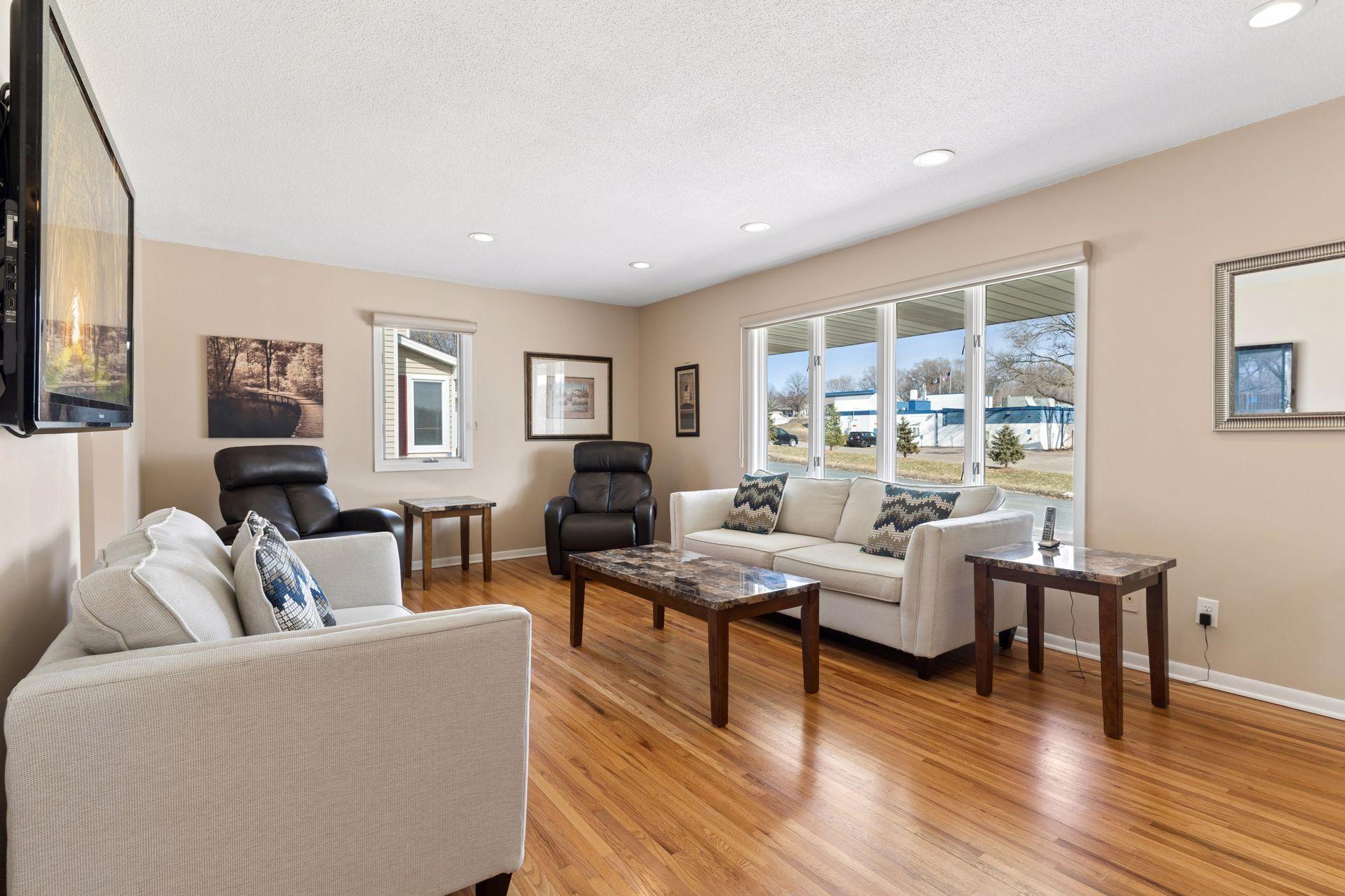 Bright and open front living room featuring gleaming hardwood floors and large east facing picture window.