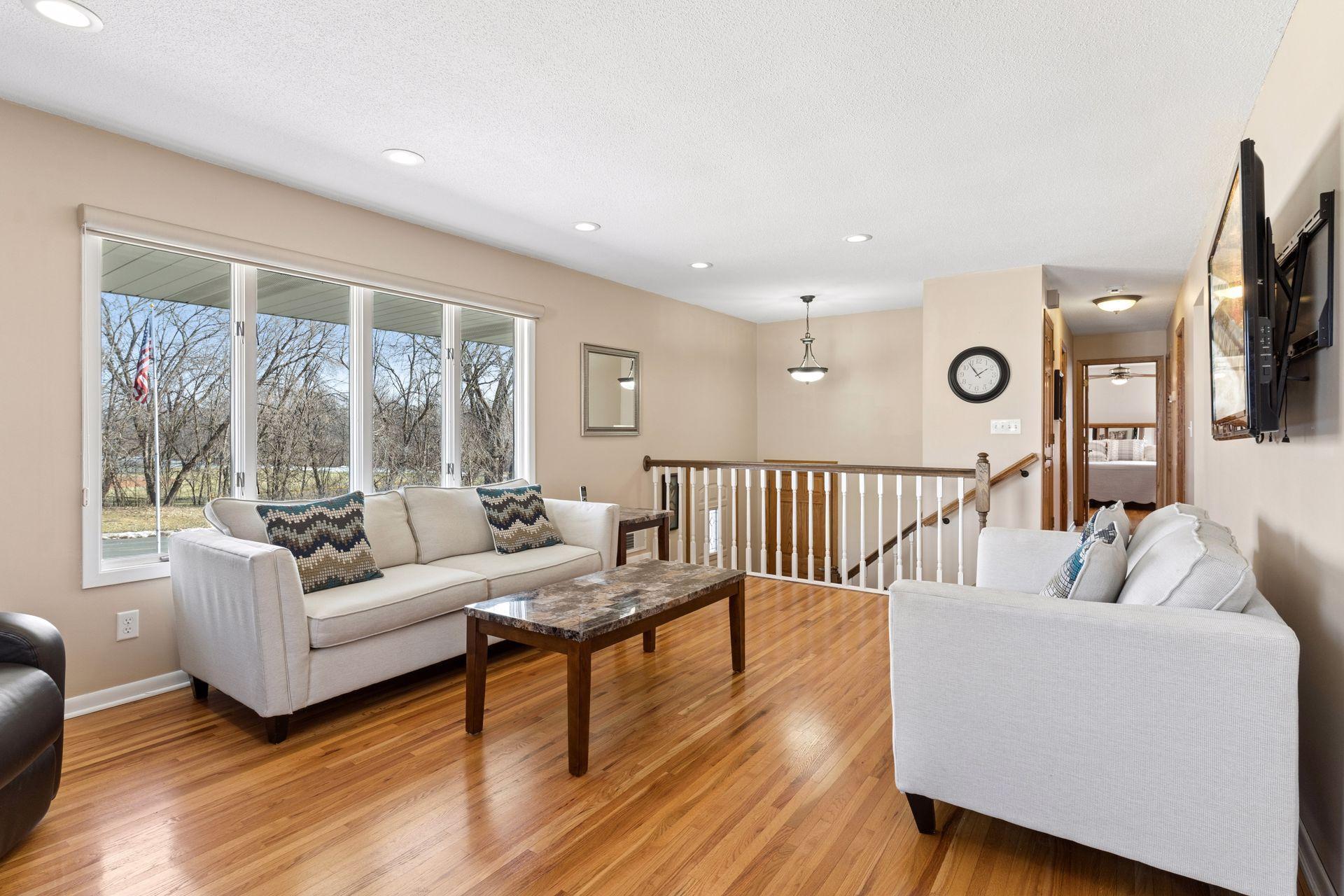 Picture window provides a backdrop of beautiful mature trees in the summer.