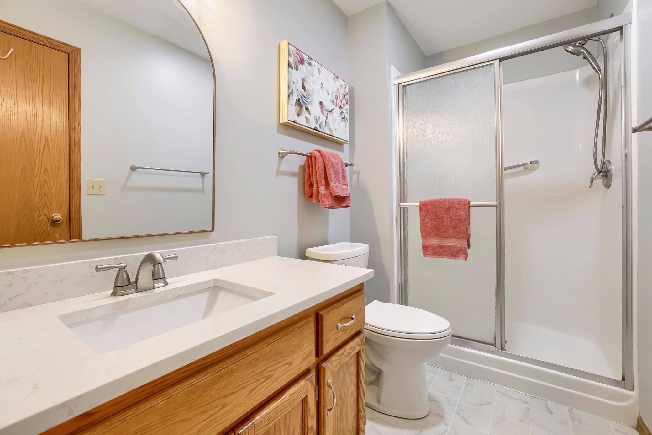 The updated owners' suite bath with quartz countertop