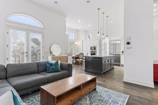 Light-filled family room/great room featuring built-in cabinetry, warm hardwood floors, and soaring ceilings for an open and inviting feel.
