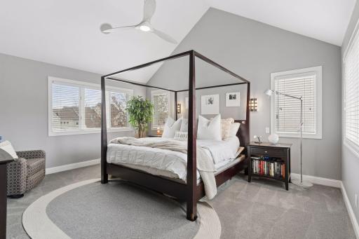 Spacious primary suite with vaulted ceilings and three sides of large windows. A peaceful retreat filled with natural light.