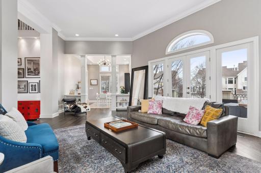 Stunning living room with soaring ceilings, oversized windows, elegant architectural columns, and open sightlines to surrounding spaces