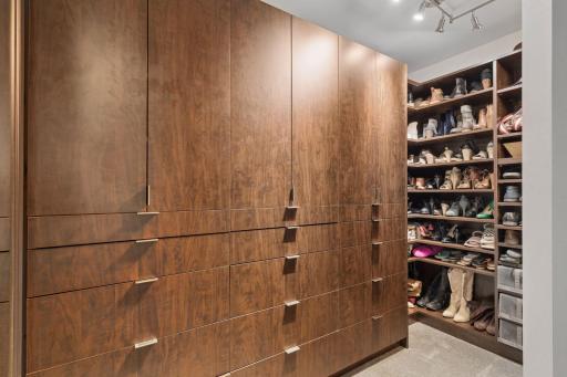 Generous walk-in closet with extensive built-in storage, drawers, and open shelving for organized wardrobe space.