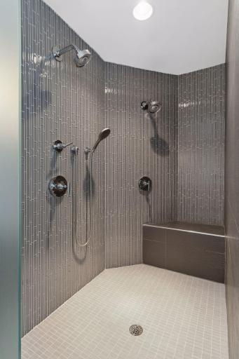 Large, walk-in primary shower with multiple shower heads and gorgeous tile work.