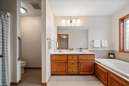 The primary bathroom is spacious with double sinks and a separate bathtub and shower.