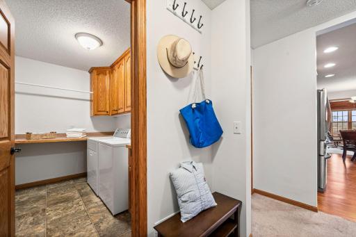 The laundry room is conveniently located next to the garage entrance and has extra cabinetry for storage.