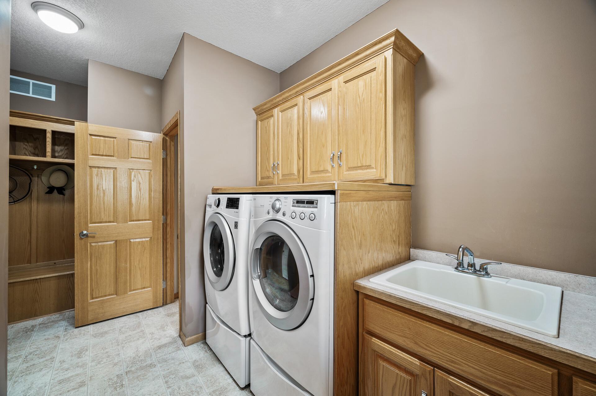 Huge main floor laundry with built in custom cabinets.