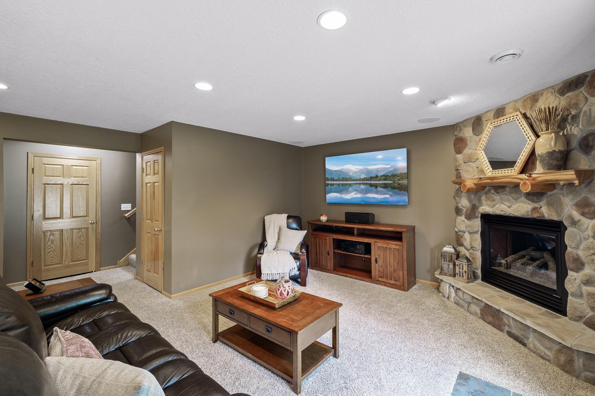 Lower level is prefect to cozy up to the beautiful stone fireplace.