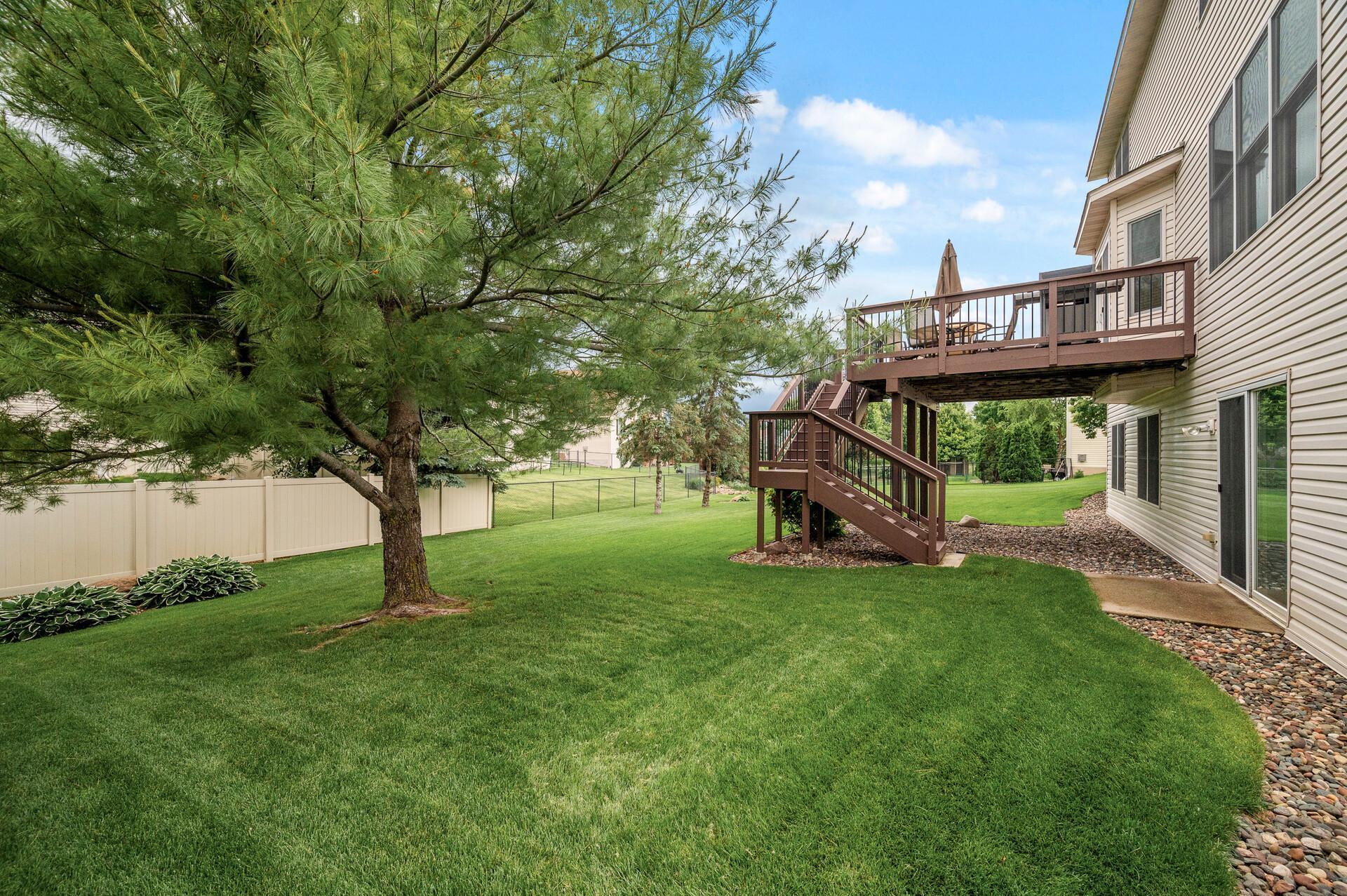 Wide steps to the lush backyard, with stunning black aluminum railing. Picture taken fall 2025