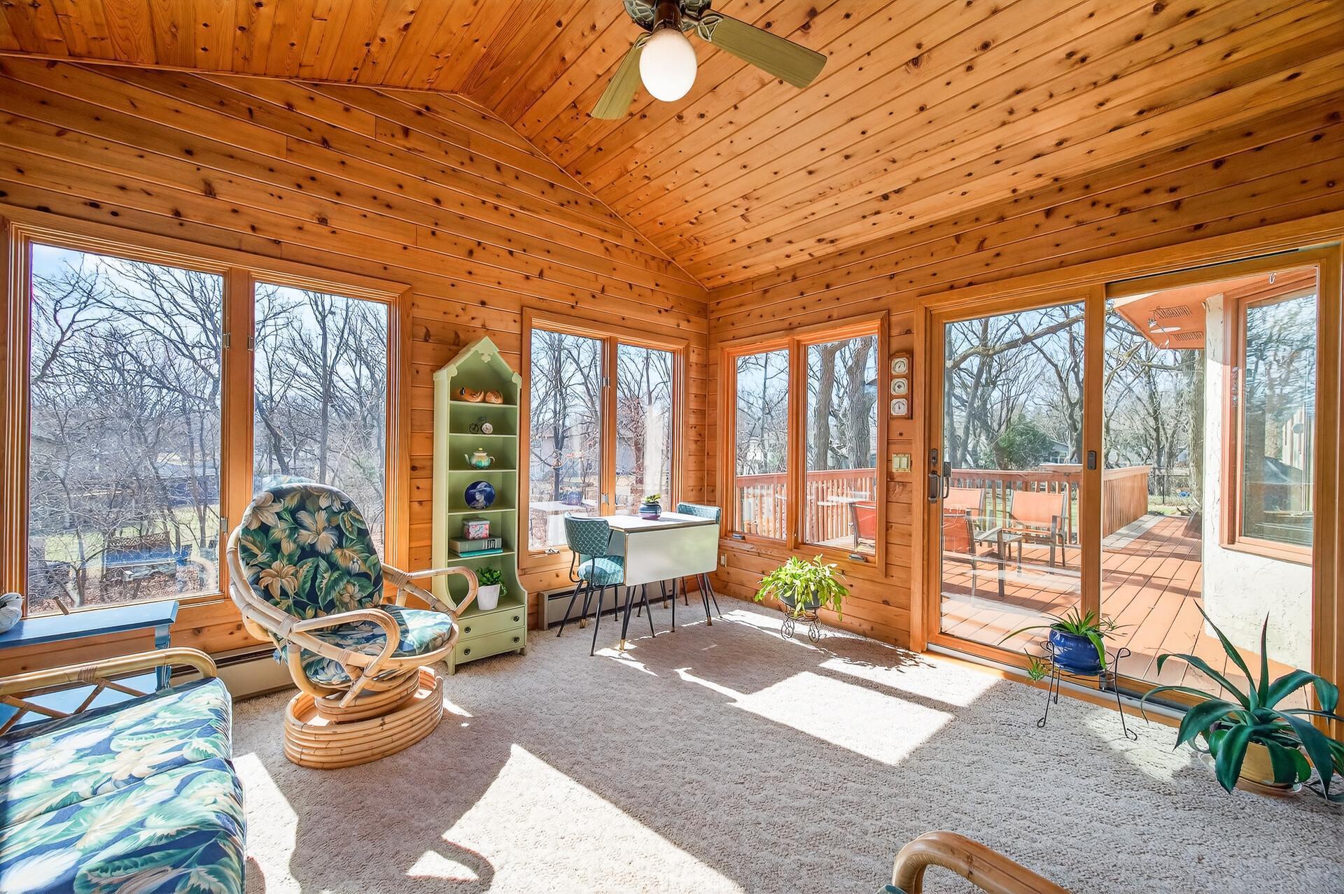 Stunning 4-season porch wrapped in windows and natural wood tones
