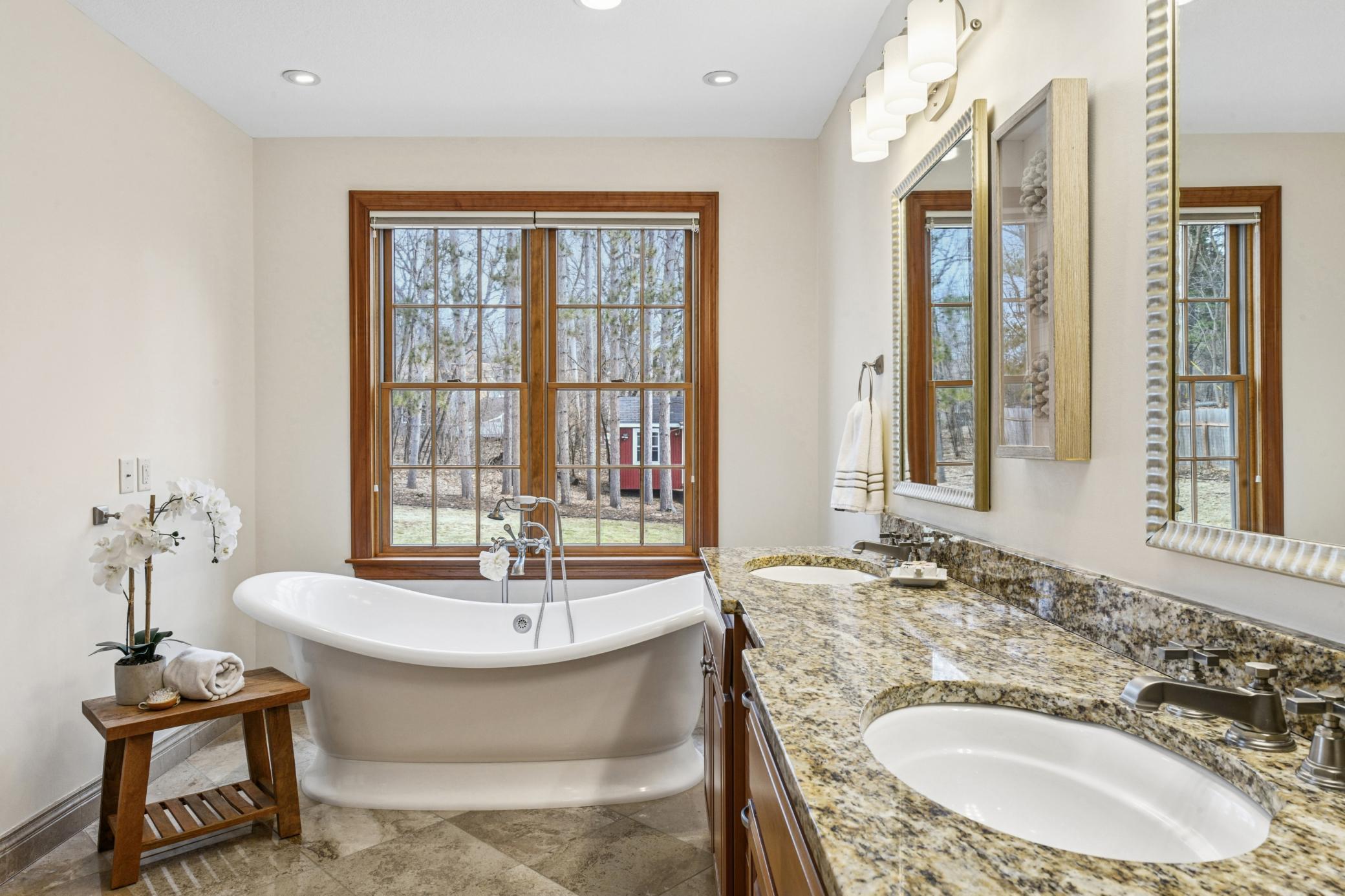 Relax in a soaking tub overlooking serene natural surroundings, with the comfort of heated floors underfoot