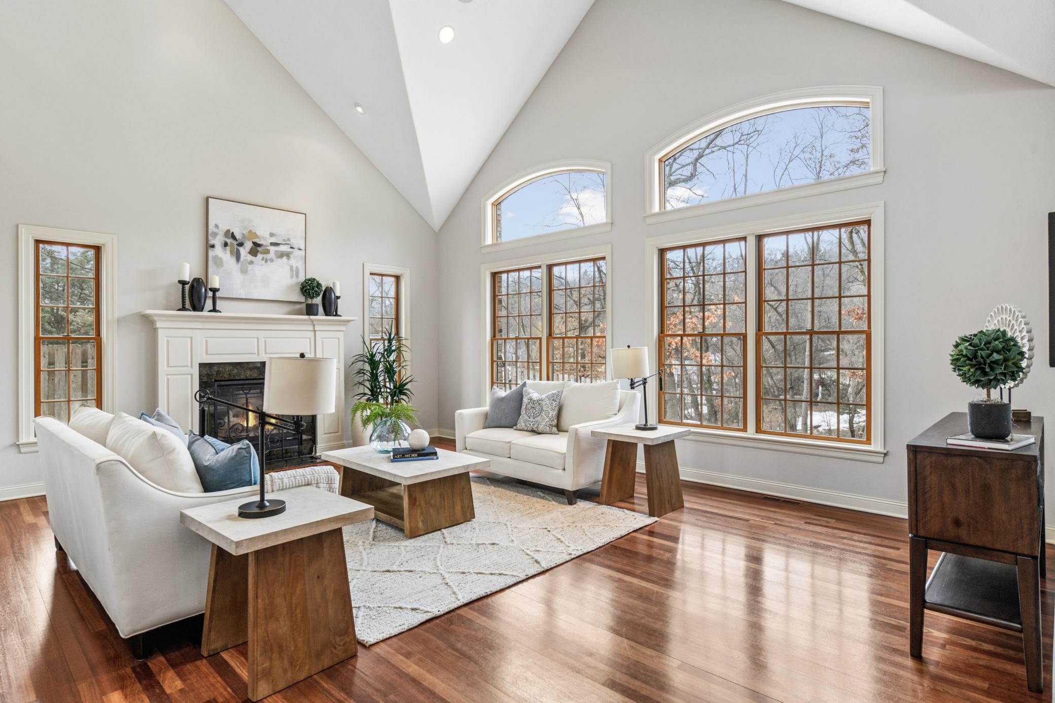 A warm welcome: this sun bathed formal living room anchored by a stunning fireplace