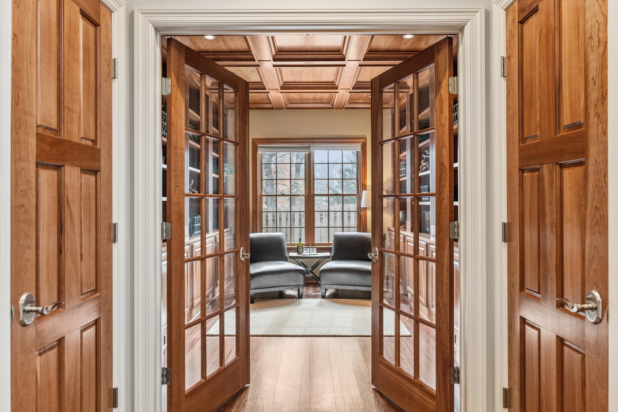 French doors lead to this breathtaking space with floor to ceiling wood paneling, ideal for a quiet library space or home office