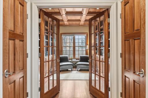 French doors lead to this breathtaking space with floor to ceiling wood paneling, ideal for a quiet library space or home office