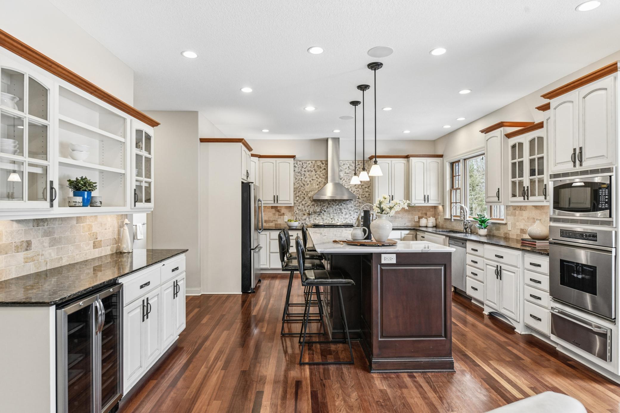 Just a stunning kitchen with dreamy storage, large island with Cambria countertops and a mix of color and textures throughout