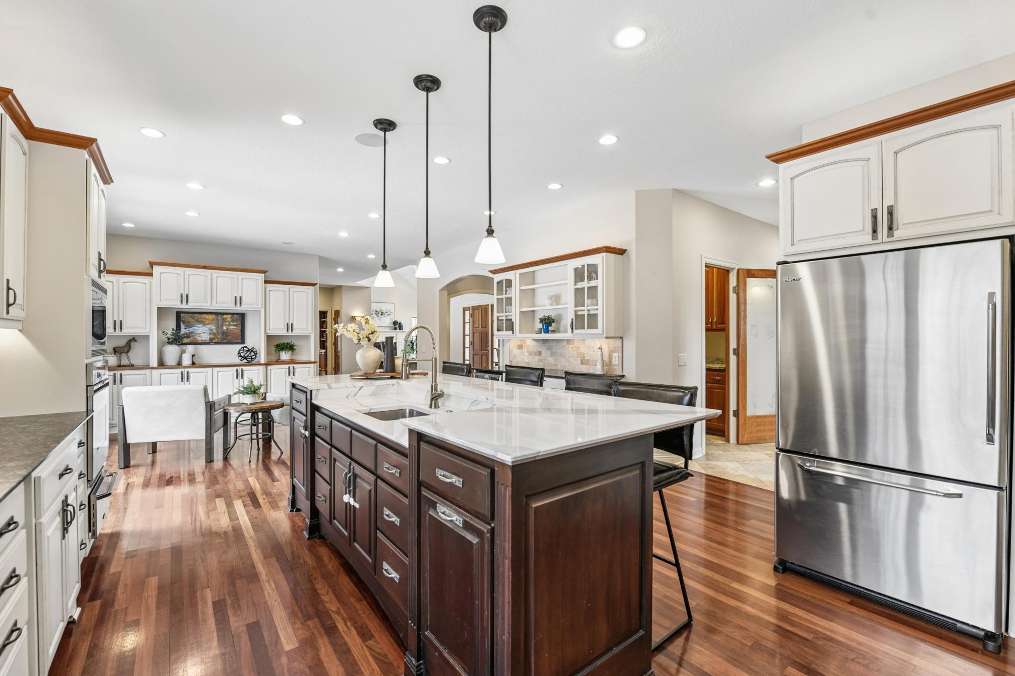 Heated floors guide you to a generous pantry, powder room, laundry room with a dog door, and access to the heated garage