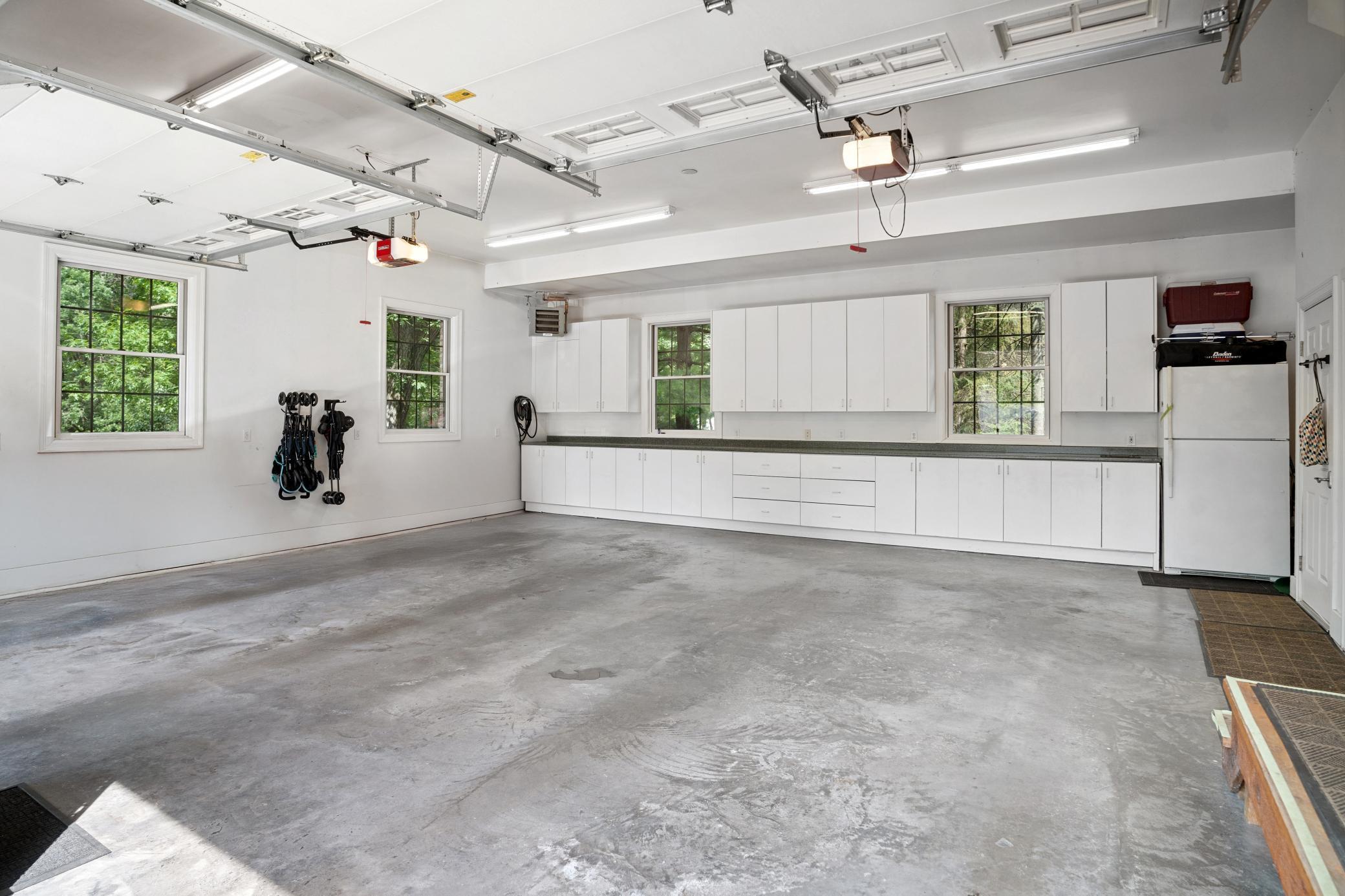 Spacious upper two car heated garage featuring outstanding storage, refrigerator, EV charger readiness, and convenient private access to the apartment