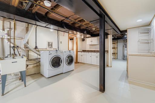 Laundry room with sink and there are quite a few cabinets for a workshop, plus there is the utility room in the back with alot off storage space