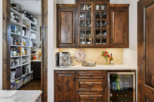 The coffee and wine bar is great for storing all your beverages. Next to the bar is a spacious walk-in pantry with custom shelving and cabinetry.