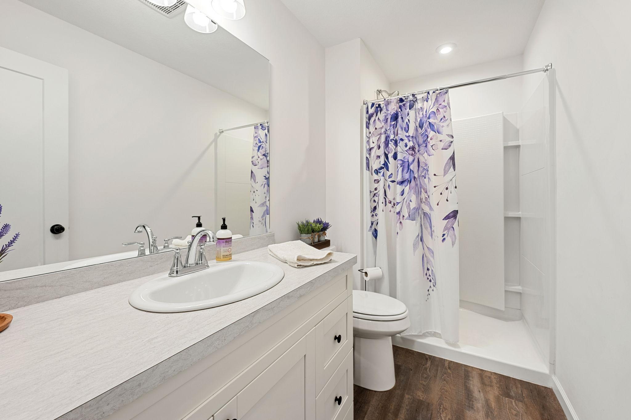 Spa-list primary bath with walk-in shower stall and large vanity.