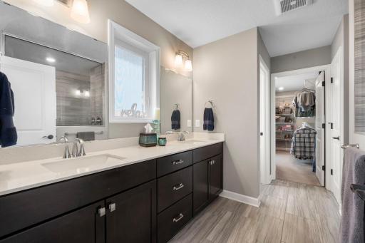 The primary bathroom has double sinks and leads to the largest of the two walk-in closets.