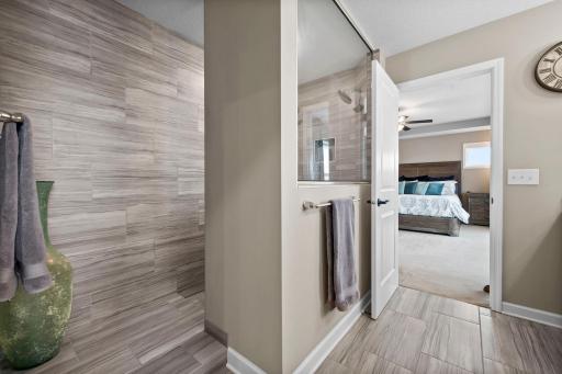 The luxurious tile shower is bright and light-filled.