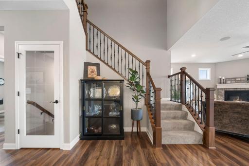 The open stairway leading upstairs features wood railings and iron spindles.