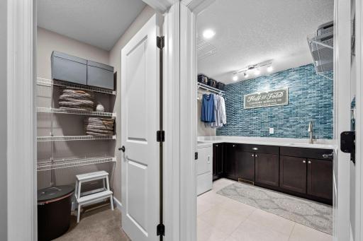 The oversized laundry room is located on the upper level with a storage room nearby!