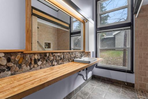 Awesome bath room with stylish sink, countertops and gorgeous stone accents.